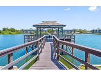 Water view of dock with seating area on a sunny day surrounded by trees and blue water at 11485 Oakhurst Rd # 312, Largo, FL 33774