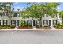 Charming townhome with neutral siding, black shutters, and manicured landscaping, offering curb appeal at 11541 Fountainhead Dr, Tampa, FL 33626