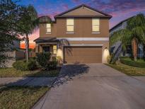 Charming two-story home featuring a well-maintained lawn, mature trees, and attached two car garage at 15306 Broad Brush Dr, Sun City Center, FL 33573