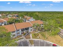 An aerial view showcases the complex with its lush surroundings, close to water, and easy access to parking at 1930 Laughing Gull Ln # 1225, Clearwater, FL 33762