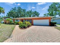 Charming single-story home with a well-manicured front yard and a brick-paved driveway leading to a two-car garage at 2505 E 19Th Ave, Tampa, FL 33605