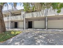 Condominium exterior featuring individual garages and an inviting facade with mature landscaping at 301 2Nd N St # 13, St Petersburg, FL 33701