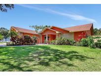 Charming single-story home with colorful landscaping and a well-maintained lawn at 3122 Lake Valencia E Ln, Palm Harbor, FL 34684