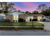 Charming single-story home with stone accents, lush landscaping, and well-lit windows at 3139 Corona Dr, Holiday, FL 34690