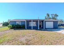 Charming single-story home with blue siding, front porch, and an attached one car garage at 3445 Briar Cliff Dr, Holiday, FL 34691