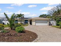 Charming single-story home with a well-manicured yard and brick driveway at 3497 Coquina Key Se Dr, St Petersburg, FL 33705