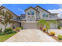 Beautiful two-story home with stone accents, a two-car garage, and a nicely paved driveway at 4697 Wandering Way, Wesley Chapel, FL 33544