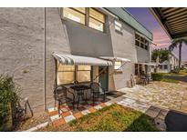 Condo exterior showcasing a quaint patio area with seating and colorful surroundings at 5216 81St N St # 2, St Petersburg, FL 33709
