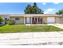 Charming single-story home with well-maintained lawn, garden, and attached one-car garage at 608 Lemonwood Dr, Oldsmar, FL 34677
