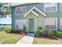 Charming home featuring a welcoming front door, complemented by an array of colorful potted plants at 9304 Lake Chase Island Way, Tampa, FL 33626