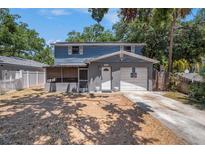 Charming two-story home featuring blue siding, a covered porch, and a one-car garage at 3115 W Wyoming Ave, Tampa, FL 33611