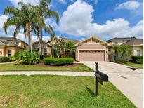 Charming single-story home with manicured front lawn, mature landscaping, and two-car garage at 3254 Grassglen Pl, Wesley Chapel, FL 33544