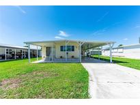 Charming single-story home featuring a covered carport and well-maintained front yard with sunny curb appeal at 36848 Beth Ave, Zephyrhills, FL 33542