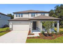 Beautiful two-story home featuring a covered entry, two car garage, and tastefully landscaped front yard at 37194 Clinch Cir, Zephyrhills, FL 33540