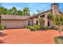 Inviting single-Gathering home with a 2-car garage, chimney, mature landscaping, and a red brick driveway at 713 Dorado Ct, Brandon, FL 33511
