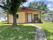 Charming yellow home exterior with a curved sidewalk leading to the front door and well-maintained lawn at 772 71St N Ave, St Petersburg, FL 33702
