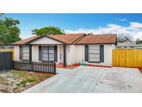 Charming single-story home with a well-maintained lawn, fresh exterior paint and ample parking space at 9201 Spy Glass Ct, Tampa, FL 33615