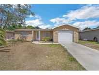 Charming single Gathering home featuring an attached garage and traditional landscaping at 10016 Glen Moor Ln, Port Richey, FL 34668