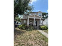 Charming two-story home featuring a covered front porch with decorative pillars and landscaped yard at 1706 W Beach St, Tampa, FL 33607
