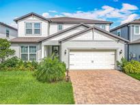 Charming two-story home with well-maintained landscaping and a brick paver driveway at 17683 Ramble On Way, Land O Lakes, FL 34638