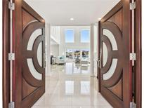 Grand entryway featuring custom double doors and a view into a spacious living area with water views at 2233 Donato Dr, Belleair Beach, FL 33786
