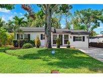 Charming home with mature trees, lush lawn, and a well-kept landscape at 3914 W Cleveland St, Tampa, FL 33609