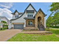 Beautiful two-story home with a stone facade, arched entryway, and well-manicured lawn at 4224 W Corona St, Tampa, FL 33629