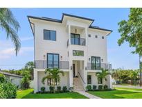 Striking three-story modern home featuring a white exterior, multiple balconies, and manicured landscaping at 500 E Davis Blvd, Tampa, FL 33606