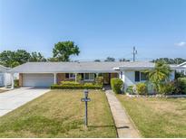 Charming single-story home featuring a well-manicured lawn, a brick accent, and a cozy front porch at 5877 33Rd N Ave, St Petersburg, FL 33710