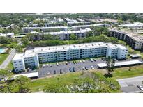 Expansive aerial view of a multi-story apartment building with ample parking surrounded by lush greenery at 5970 80Th Street North # 206, St Petersburg, FL 33709