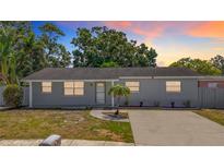 Charming single-story home with fresh gray paint and a well-manicured front yard and a large driveway at 8345 81St Ct, Seminole, FL 33777