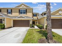Charming two-story townhome featuring a well-maintained lawn, attached garage, and inviting curb appeal at 8518 Broken Willow Ct, Tampa, FL 33647
