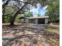 Charming single-story home with attached carport and mature trees in a peaceful setting at 9830 Sheryl Dr, New Port Richey, FL 34654