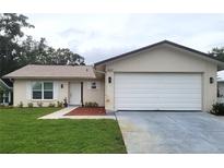 Charming single-story home features a well-manicured lawn, attached garage and inviting front entrance at 10627 Mira Vista Dr, Port Richey, FL 34668