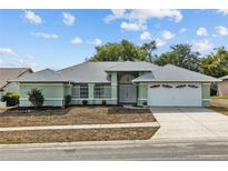 Charming single-story home with a well-maintained lawn, two car garage, and a quaint, welcoming entrance at 1247 Venetia Dr, Spring Hill, FL 34608