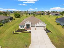 Expansive aerial shot of a single-story home with beautiful landscaping and well-maintained surroundings at 13953 Thoroughbred Dr, Dade City, FL 33525