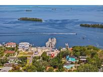 Stunning aerial view of waterfront property with a boat dock and breathtaking views of the bay and surrounding islands at 273 Shore Dr, Palm Harbor, FL 34683