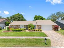 Charming single Gathering home featuring stone accents, green lawn, and a two car garage at 2850 Allapattah Dr, Clearwater, FL 33761