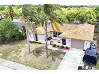 Single Gathering home with updated tile roof, well-manicured landscaping, and a spacious driveway at 3301 Elkridge Dr, Holiday, FL 34691
