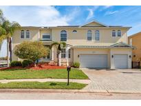 Two-story home featuring a three-car garage, beautiful landscaping, and classic architectural detailing at 339 Manatee Ln, Tarpon Springs, FL 34689