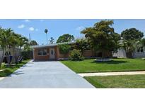 Charming single-story home featuring a well-maintained lawn and a long concrete driveway at 4018 Indianapolis Ne St, St Petersburg, FL 33703