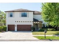 Charming two-story home featuring a brick driveway, three-car garage, and manicured landscaping at 4204 W San Juan St, Tampa, FL 33629