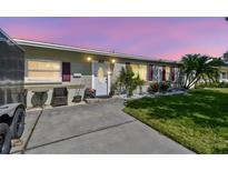 Charming single-story home with a well-manicured lawn, tropical plants, and a cozy front porch setup at 8431 52Nd N Way, Pinellas Park, FL 33781