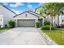 Charming home with a two-car garage, well-maintained landscaping and a gray facade at 9617 Channing Hill Dr Dr, Ruskin, FL 33573