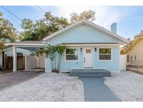 Charming light blue home featuring a quaint front yard and a convenient covered carport at 110 Kenwood Ave, Clearwater, FL 33755