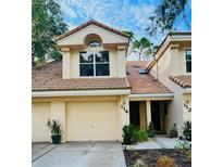 Inviting two-story townhouse featuring a tile roof, a one-car garage, and well-maintained landscaping at 114 Clays Trl # 114, Oldsmar, FL 34677