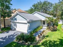 Charming single-story home featuring a well-manicured lawn and attached two-car garage at 11932 Whisper Creek Dr, Riverview, FL 33569