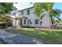 A two-story home showcases a well-manicured lawn with attractive landscaping, enhancing the property's curb appeal at 212 W Floribraska Ave, Tampa, FL 33603