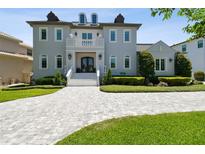 Elegant two-story home with a grand entrance, lush landscaping, and a beautifully paved driveway at 2604 S Bryant Cir, Tampa, FL 33629