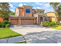 Attractive two-story home with a three-car garage, stone entrance, and well-manicured lawn and landscaping at 32718 Summerglade Dr, Wesley Chapel, FL 33545